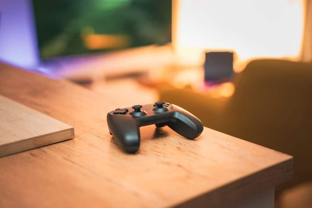 What Is IPTV Extreme? (Not the Same as Xtream Codes) Game controller on a wooden table with warm lighting