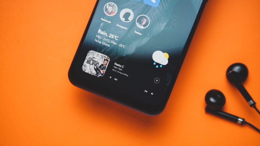 Televizo IPTV Player: Features & Setup Guide Smartphone with earbuds on an orange background