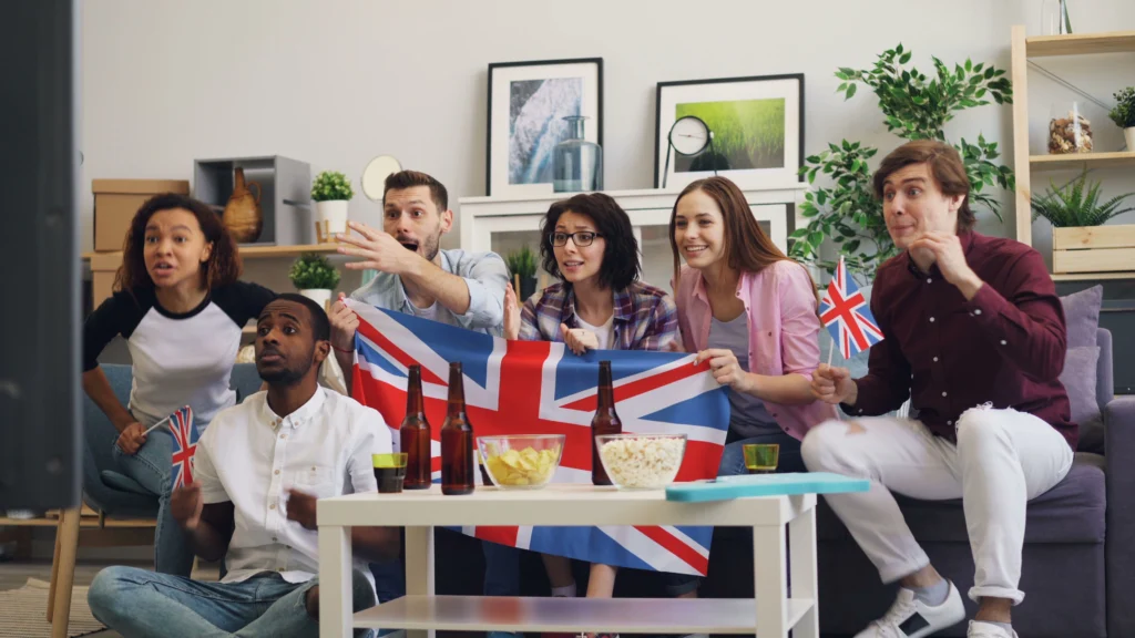 British IPTV: The Complete Guide for UK Viewers Group of friends watching TV together at home in the UK, holding a Union Jack flag